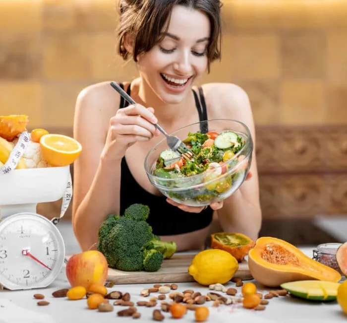 Woman enjoying a fresh, balanced salad as part of a healthy weight loss routine with SodaFit