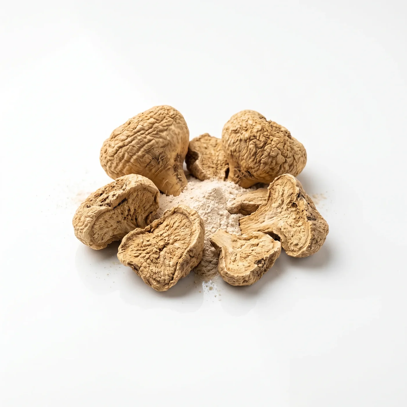 Dried maca root pieces and powder on a white background